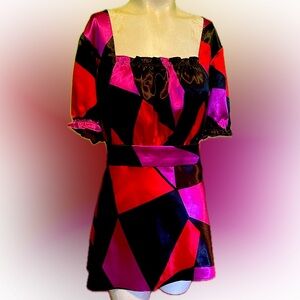 Bold geometric patterned women’s top in red, pink and black. Short sleeves.